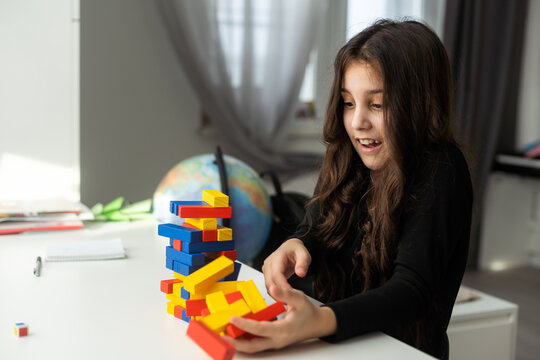 Children building wood blocks at playground. Girl kid playing stacking wood blocks (Jenga games) for meditation practice. Hand movement control Building Computational Skills Children's play concept.