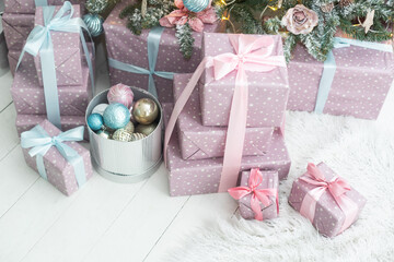 Beautiful Christmas gifts under fir tree on floor in room.