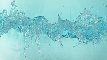Naklejka na ściany i meble Freeze motion of splashing water surface on light blue background
