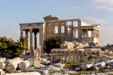 Fototapeta na wymiar The ruines at Acropilis hill in a summer day, defocused Erechtheum temple as background. Beautiful wallpaper. Art, history or tourism concept. Athens, Greece