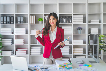 Asian happy beautiful businesswoman in formal suit work in workplace. Attractive female employee office worker smile.