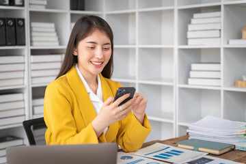 Young business woman, smiling pretty professional businesswoman worker looking at smartphone using cellphone mobile technology working at home or in office.