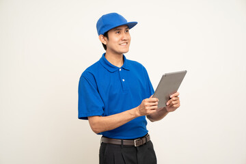 Asian man in blue uniform standing holding digital tablet computer on isolated white background. Male service worker with cell phone. Delivery courier shipping service