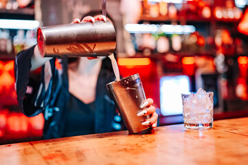 woman hand bartender making cocktail in glass on the bar counter