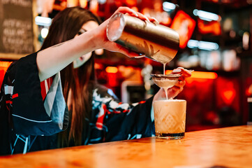woman hand bartender making cocktail in glass on the bar counter