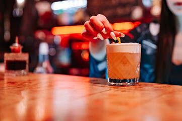 woman hand bartender making cocktail in glass on the bar counter