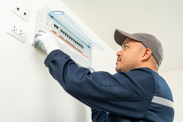 Portrait electrician man in uniform maintenance or fixing switches sockets  circuit breaker...