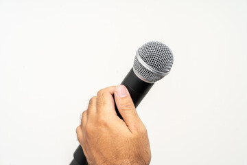Close up male hand holding High quality dynamic microphone and singing song or speaking talking with people on isolated white background. Male testing microphone voice for interview