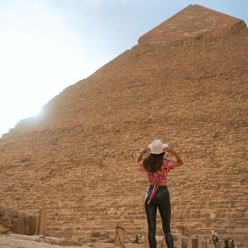 Tall Beautiful Young Girl Looking at the Pyramid of Giza in sunshine