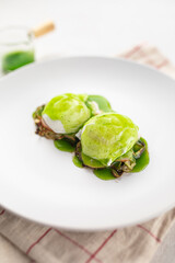 Portion of gourmet breakfast with poached egg and green sauce