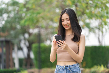 Happy feeling of beautiful Young woman using and text on smartphone. She shopping online. She smile very happy. Teenage girl reading news from mobile cell phone feeling excited.