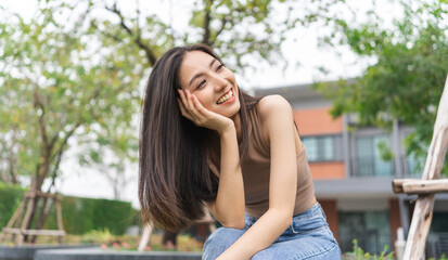 Happy feeling of Beautiful Young Woman smiling outdoor in sunlight. Pretty attractive face of female and beautiful smile. She is positive thinking and successful.