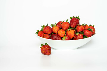Strawberries in a white ceramic tray, on a white background. Eating healthy