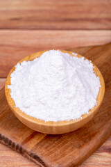 Fototapeta na wymiar Powdered sugar on wooden background. Powdered or icing sugar in wood bowl