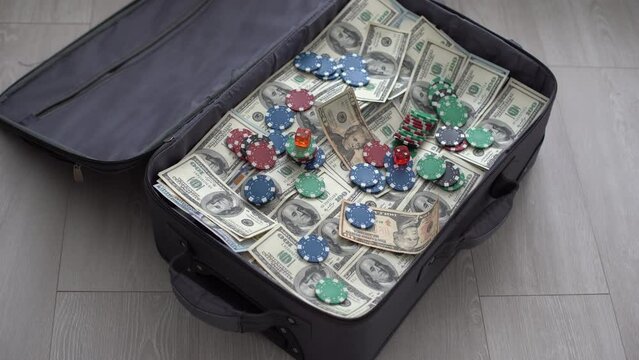 an old black suitcase with an open lid full of one hundred dollar bills. Corruption