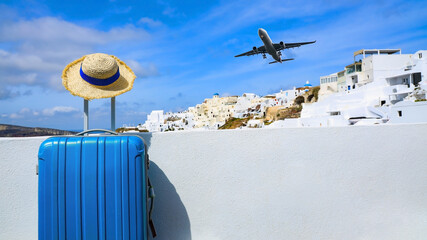 Blue luggage and hat as landscape view of Oia town in Santorini island in Greece , Greek landscape...