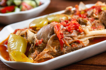 Khashlama is popular Armenian dish, which is prepared from beef with vegetables. Khashlama in the plate. stewed lamb on the bone with vegetables on wooden desk