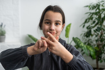 Beautiful smiling deaf girl using sign language.