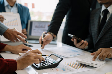 Businessmen team or financial data analysts working with tablets and laptop computers and data...
