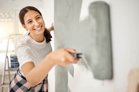 Woman, renovation and painting a home wall in DIY, house project or maintenance or construction, interior design and decoration. Paint, bedroom or remodel space with paintbrush, roller and painter