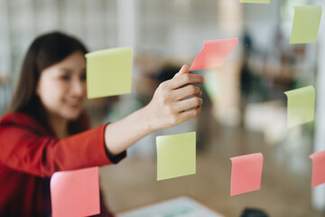 Beautiful young teen asian businesswoman using note pad thinking  with planning working on financial document, tax, exchange, accounting and Financial advisor