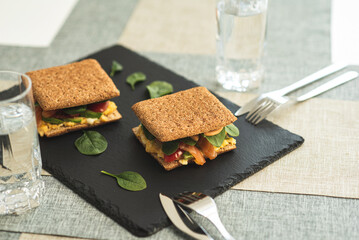 Sandwich with cereals bread and salmon on dark marble background