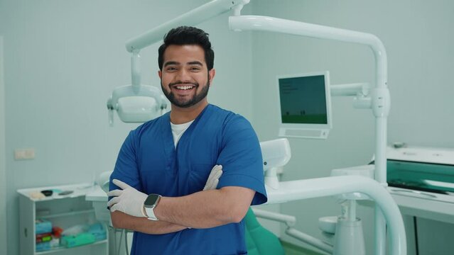 Laughing indian male dentist looking at camera in hospital. Dentist appointment