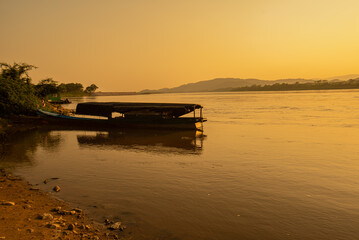 View of the morning Mekong River surrounded by mountains and yellow sunbeams in the sunset background at Chiang Khong, Chiang Rai, northern Thailand.
