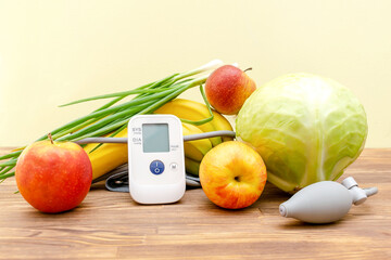 Tonometer glucose meter,vegetables,fruits,heart pressure,proper nutrition,healthy lifestyle,lowering blood sugar,diabetes concept on yellow,wooden background