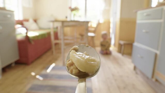 Dessert travels through kitchen to toddler waiting with open mouth, spoon POV