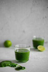 	
Green smoothie with spinach, banana and lime in small bottles and glass. Raw, vegan, vegetarian, healthy food concept