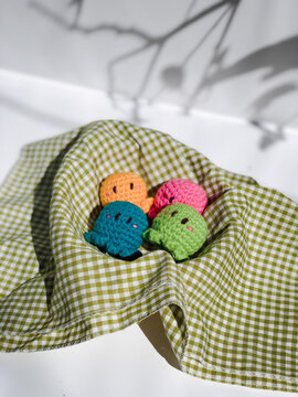 Handmade knitted soft key chain. Amigurumi. Miniature Octopus key chain with several colors of knitted on white background. Selective focus.