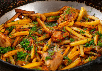 Roasted meat and potatoes in an iron pan