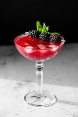 Blackberry Cocktail Blackberry Martini with fresh berries, ice and mint. Refreshing alcoholic drink with blackberry and ice on a stone grey background. Cocktail drink photography