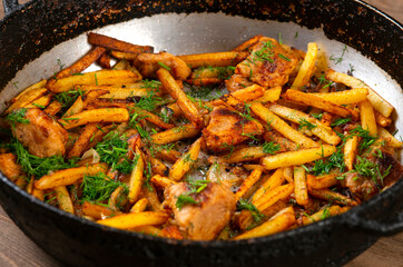 Roasted meat and potatoes in an iron pan