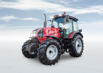 Modern wheeled tractor isolated on bright background with sky