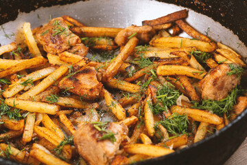Roasted meat and potatoes in an iron pan