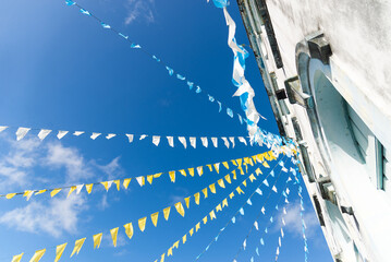 Upper facade of the Matriz church decorated with yellow flags for the feast of Sao Joao. - obrazy, fototapety, plakaty