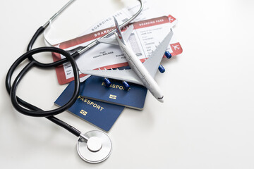 Medical Tourism, medical travel concept. Stethoscope, toy plane and passport on grey background.