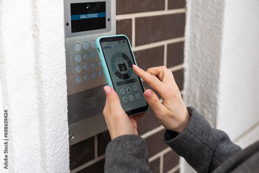 Poster young stylish woman getting access to the building by attaching smartphone to intercom. concept of m