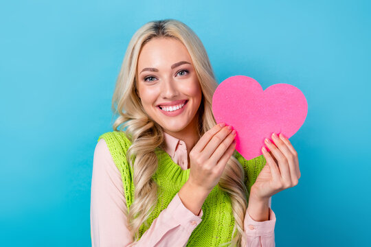 Closeup photo of young blonde girl hold her pink postcard love shape heart valentine day celebration isolated on blue color background