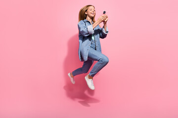 Photo of cheerful excited joyful girl wear denim stylish outfit go modern technology shop buy iphone isolated on pink color background