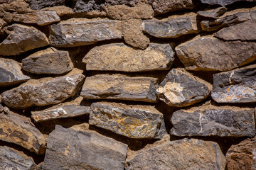 Stone antique old wall as a background or texture. Vintage background of a fortress wall in loft and grunge style with place for text and copy space.