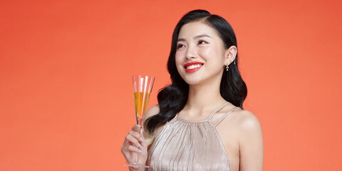 Beautiful asian girl in evening dress smiling, holding glass of champagne