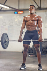 Fototapeta na wymiar Fitness, muscle and a black man bodybuilder with a barbell in the gym during a physical workout routine. Exercise, strong and sweat with a shirtless male athlete lifting weights in a sports center