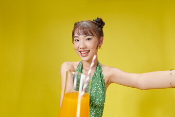 Cute lady holding glass with tropical beverage in hand isolated on bright vivid background