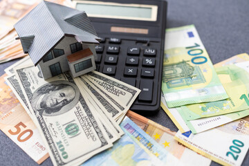 The concept of mortgage and rental housing and real estate. Mortgage credit lending. House of euro bills on the plan of the house and laid out dollar banknotes on a blue background