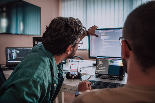 Programmers engrossed in deep collaboration, diligently working together to solve complex problems and develop innovative mobile applications with seamless functionality.