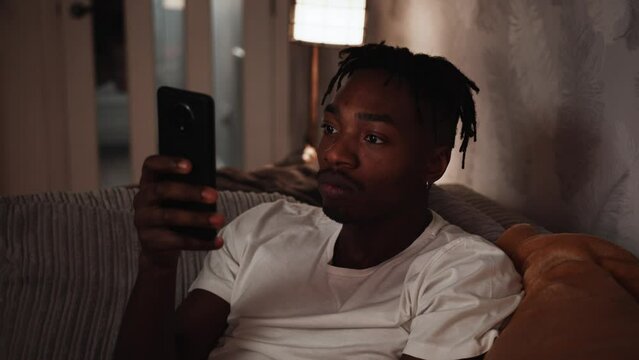 Young black male reacts shocked to what he's seeing on his smart phone