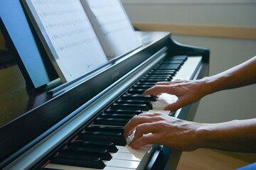 Alumna o profesora de piano tocando el instrumento donde se aprecia la digitación y close-up de...